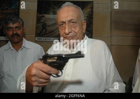 Radio-Nachrichtensprecher Surajit Sen übergibt am Montag, 26. September 2005, eine pakistanische Pistole an den indischen Armeegeneral J.J. Singh in Neu-Delhi. Die Pistenliste Stockfoto