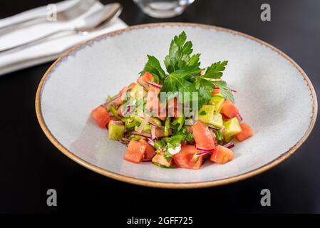 Türkischer Coban (Choban)-Salat oder Shepherds-Salat auf schwarzem Tisch. Stockfoto