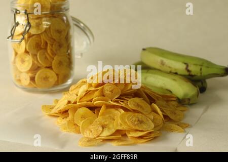 Gebratene Bananenchips, die durch Frittieren unter reifen Bananenscheiben hergestellt werden. Ein Hauptbestandteil der vegetarischen Onam-Mahlzeiten im Volksmund auch Ethakka upperi genannt. Schuss auf weiß b Stockfoto