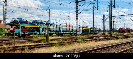 Transport von Autos mit dem Zug. Autorack mit Autos. Beladene Autos bereit für den Transport. Transport von Autos auf dem Bahnsteig Stockfoto