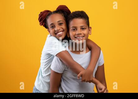 Nettes schwarzes Teenager-Mädchen umarmte Bruder und zeigte ihre Zuneigung Stockfoto