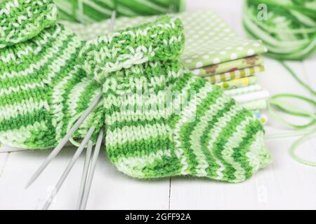 Baby Strick Socken auf einem weißen Holzhintergrund Stockfoto