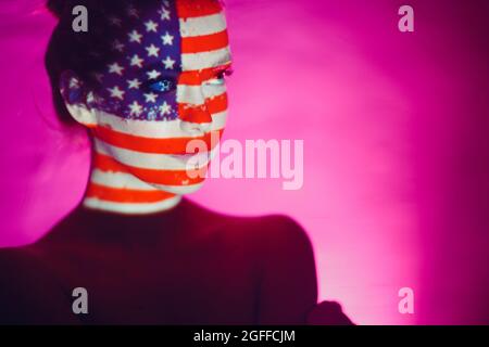 Junge Frau mit US-Flagge im Gesicht. Stockfoto