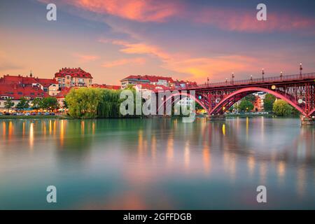 Maribor, Slowenien. Stadtbild von Maribor, Slowenien bei schönem Sommeruntergang mit Spiegelung der Stadt in der Drau. Stockfoto