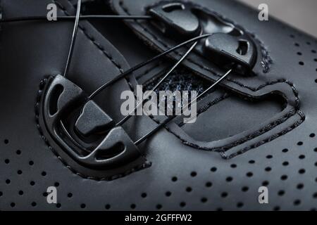 Teil der Schuhe aus schwarzem perforiertem Leder in Nahaufnahme. Makro Stockfoto