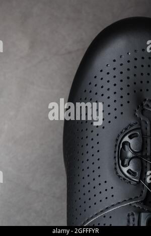 Teil der Schuhe aus schwarzem perforiertem Leder in Nahaufnahme. Makro Stockfoto