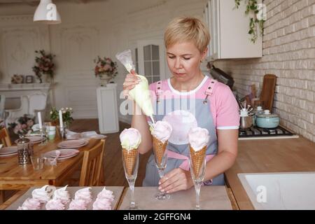 Konditor Herstellung von marsmalow Desserts mit Gebäck Beutel in der Küche Stockfoto