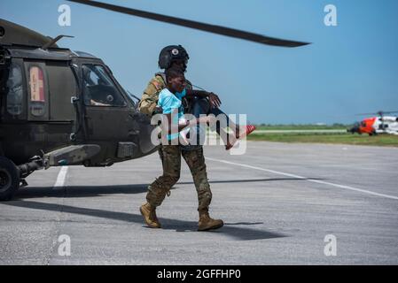 Port Au Prince, Haiti. August 2021. Der US-Armeekapitäter Alix Idrache hilft mit dem 228. Aviation Regiment während einer medizinischen Evakuierungsmission am 24. August 2021 in Port-au-Prince, Haiti, einen Patienten aus einem UH-60 Black Hawk-Hubschrauber zu entladen. Das Militär unterstützt die Folgen des jüngsten Erdbebens. Quelle: Planetpix/Alamy Live News Stockfoto