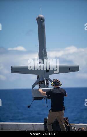 Das VBAT Unmanned Aerial Drone System der US Navy wird von einem Betreiber stabilisiert, da es einen vertikalen Abhub vom Flugdeck des Amphibientransportsdocks USS Portland am 17. August 2021 im Pazifischen Ozean durchführt. Stockfoto