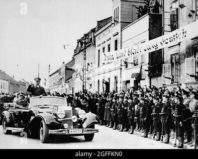 Adolf Hitler in Memel im März 1939, nachdem die nazis das Gebiet von Litauen annektierten (Klaipéda auf Litauisch), nachdem sich die Litauer vor dem deutschen Ultimatum gebeugt hatten, um das Gebiet abzutreten oder sich militärischen Aktionen zu stellen. Auf dem Transparent steht: 'Dieses Land wird ewig deutsch bleiben' Stockfoto