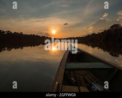 Amazonien. Blick auf den Sonnenuntergang vom Holzboot aus. Jaguar (Onza) Lagune in der Nähe des Javari River, dem Nebenfluss des Amazonas. Selva an der Grenze von Stockfoto