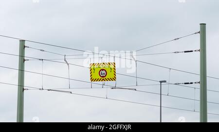 Warnschild für Hochspannung an einer Freileitung Stockfoto