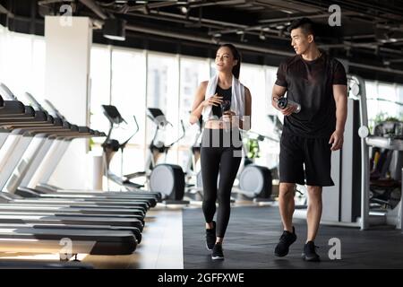 Junge Leute, die eine Pause vom Training im Fitnessstudio machen Stockfoto