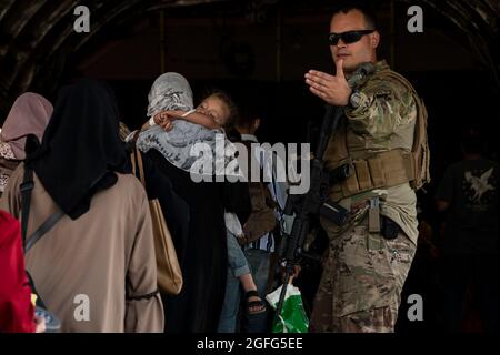 Ein US Air Force Airman führt qualifizierte Evakuierte an Bord einer C-17 Globemaster III der US Air Force zur Unterstützung der nicht kämpferischen Evakuierungsoperation am Hamid Karzai International Airport (HKIA), Afghanistan, 24. August 2021. Das US-Verteidigungsministerium hat sich verpflichtet, das US-Außenministerium beim Ausscheiden von US-amerikanischem und alliiertem Zivilpersonal aus Afghanistan zu unterstützen und die afghanischen Verbündeten in Sicherheit zu bringen. Obligatorische Gutschrift: Taylor Crol/US Air Force über CNP Stockfoto