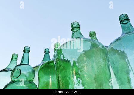 Grünes Glas Demijohns Blue Sky. Große Flaschen Stockfoto