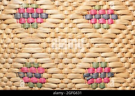 Handgefertigte Wicker- und Cattail-Weberei. Ländliche, natürliche und ökologische Textur. Farbige Rauten. Stockfoto