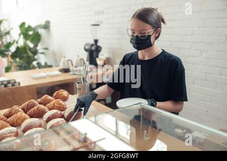 Weibliche Person in medizinischer Schutzmaske und Handschuhen Stockfoto