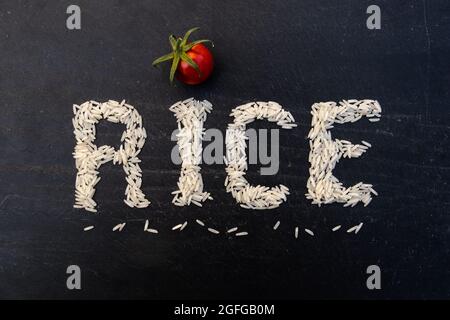 Wortreis mit weißen Körnern auf schwarzem Schiefertafel geschrieben Stockfoto