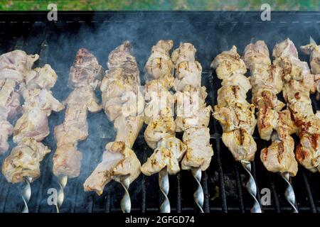 Prozess des Bratens von Fleisch auf Holzkohle im Spieß werden ein klassischer Grill gebraten Stockfoto