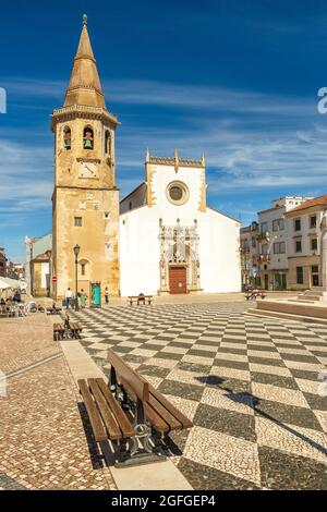 Tomar, Portugal - 3. Juni 2021: Kirche von São João Baptista in Tomar, Portugal, von der Praça da República aus gesehen, mit Bänken im Vordergrund. Stockfoto