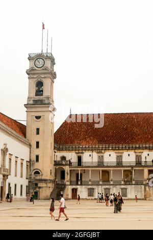 Turm der Universität Coimbra und die Touristen, die um den Platz herum spazieren, trüber Morgen - Portugal, Vertikal, August 2021 Stockfoto