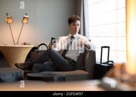 Junger Geschäftsmann im Hotelzimmer Stockfoto