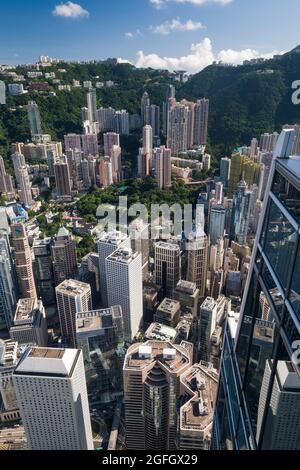 Die Hochhäuser mit Wohnhäusern in den mittleren Etagen und Luxushäusern auf dem Peak hinter den Geschäftsgebäuden von Central, Hong Kong Island Stockfoto