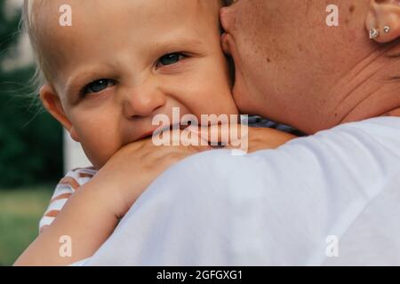 Der kleine Junge schaut seiner Mutter über die Schulter. Stockfoto