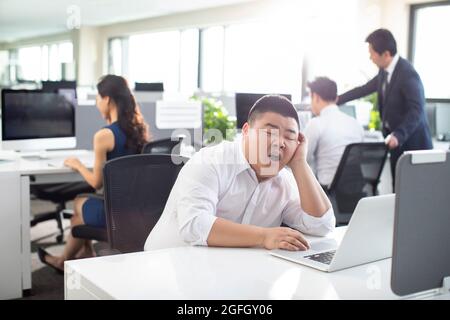 Geschäftsmann, der in den Bürozeiten nippt Stockfoto