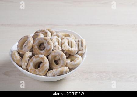 Bagels mit Glasur in einer Schüssel auf einer hellen Holzoberfläche. Platz für Ihren Text Stockfoto