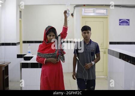 Ein Verwandter hält die Kochsalzlösung, während ein Patient, der an Dengue-Fieber leidet, im Sir Salimullah Medical College Hospital in Dhaka, Bangladesch, am 25. August 2021, einwandert. Die Zahl der Todesopfer von Dengue-Fieber erreichte 38, wobei in den 24 Stunden bis Dienstag ein weiterer Todesfall zu bekunden war, sagte ein Bericht der Generaldirektion Gesundheit (DGHS). Der Dengue-Ausbruch hat sich zu einem Anlass von großer Sorge entwickelt, da das Land in den letzten Monaten gegen die tödlichere Delta-Variante des Coronavirus mit seinen begrenzten Gesundheitseinrichtungen kämpft. Foto von Suvra Kanti das/ABACAPRESS.COM Stockfoto