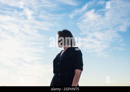 Frau steht und schaut über ihre Schulter Stockfoto