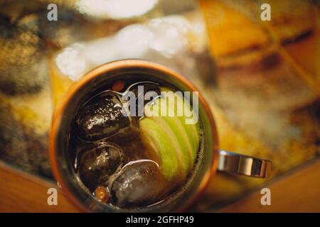 Apfelwein in einer Metallschale mit in Scheiben geschnittenen Äpfeln und Eiswürfeln Stockfoto