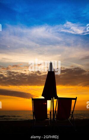 Stuhl am Strand bei Sonnenuntergang im Winter Meer gesehen Stockfoto