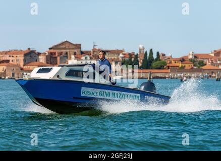 Schnellboot mit einer Person an Bord, das in der venezianischen Lagune zur Insel Murano fährt, die schnellste Art, in dieser Stadt zu reisen. Venedig, Venetien. Stockfoto