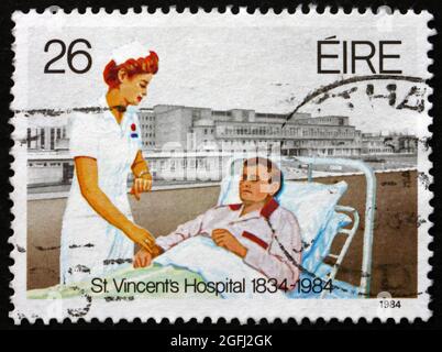 IRLAND - UM 1984: Eine in Irland gedruckte Briefmarke zeigt Krankenschwester und Patient, St. Vincent's Hospital, Dublin, Sesquicentenary, um 1984 Stockfoto