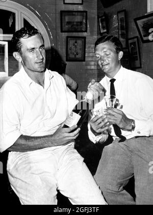 Aktenfoto vom 18-01-1963 von Englands Kapitän Ted Dexter (links) ist dabei, eine Flasche Champagner zu öffnen, um den australischen Kapitän Richie Benaud anzustoßen (rechts). Ausgabedatum: Donnerstag, 26. August 2021. Stockfoto