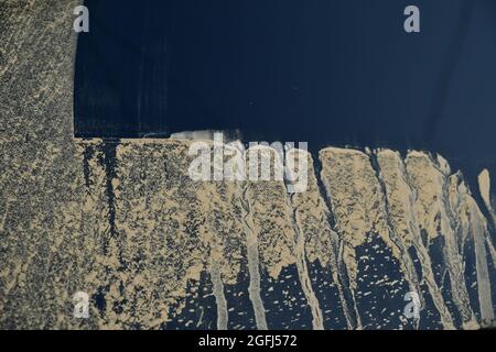 Schmutziges Autofenster nach der Fahrt im Gelände. Reinigen und Waschen schmutzige Heckscheibe mit braunen Schmutztropfen durch Fahren bei regnerischem Herbstwetter Stockfoto