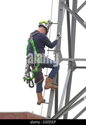 Elektriker arbeitet an einem Pol, Hochspannung Stockfoto