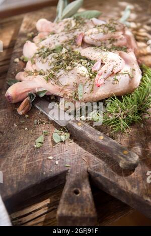 Zubereitung eines ganzen Hähnchens mit mediterranen Kräutern Stockfoto