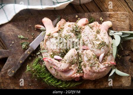 Zubereitung eines ganzen Hähnchens mit mediterranen Kräutern Stockfoto