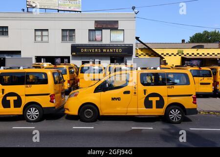 NYC Taxi Taxis parken in einer Taxigarage am McGuinness Blvd in Greenpoint, Brooklyn, mit einem Schild mit der Aufschrift „Fahrer gesucht“ im Hintergrund. 31. Juli 2021. Stockfoto