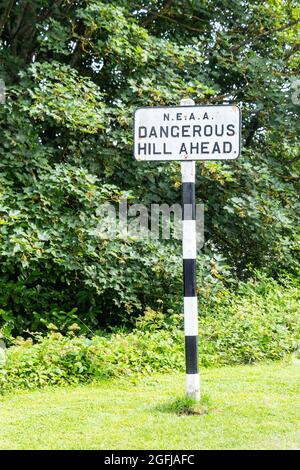 Gefährlicher Hügel vor altem Straßenschild Stockfoto