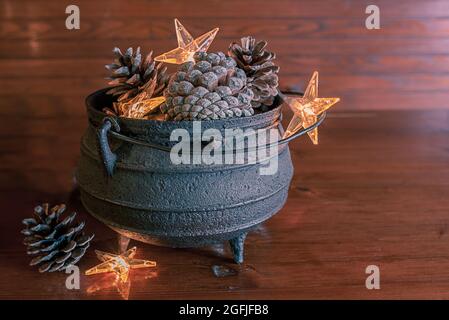 Vintage Metallkessel mit Pinienzapfen. Rustikale nordisch skandinavische Landhaus Stil Dekor. Winter Stillleben. weihnachtskarte Stockfoto