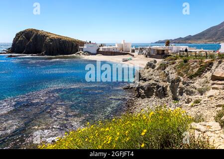 Landschaft des Küstengebiets Cabo de Gata, Provinz Almeria, Andalusien, Spanien. Landschaft mit Felsen und Häusern im Dorf La Isleta del Moro Stockfoto