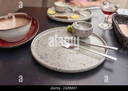 Drei leere Teller nach dem Essen, mit Gabeln und Messern. Schmutzige Teller nach dem Abendessen, Gabeln und Löffel nach dem Essen im Restaurant. Stockfoto