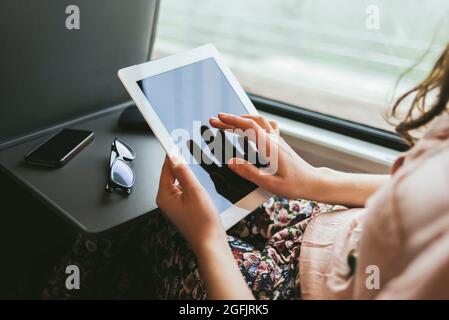 Frau mit einem digitalen Tablet im Zug Stockfoto