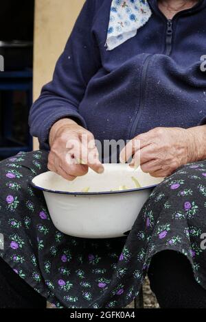 Nahaufnahme der Hände einer älteren Frau, die grüne Bohnen zum Kochen zubereitet Stockfoto