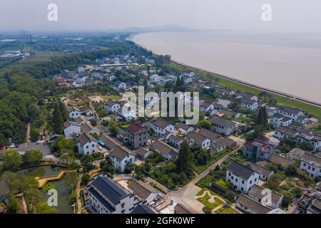 Jiaxing. August 2021. Luftaufnahme vom 26. August 2021 zeigt eine Ansicht des Dorfes Xincang in der Stadt Haining in Jiaxing, der ostchinesischen Provinz Zhejiang. Jiaxing hat seine Ressourcen im Einklang mit den lokalen Vorteilen integriert, um in den letzten Jahren eine schöne Landschaft zu schaffen, die die Entwicklung des Tourismus und der Agrarindustrie in den ländlichen Gebieten förderte. Quelle: Xu Yu/Xinhua/Alamy Live News Stockfoto