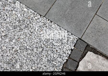 Teil einer Straße mit grauen Fliesen und Steinen. Stockfoto